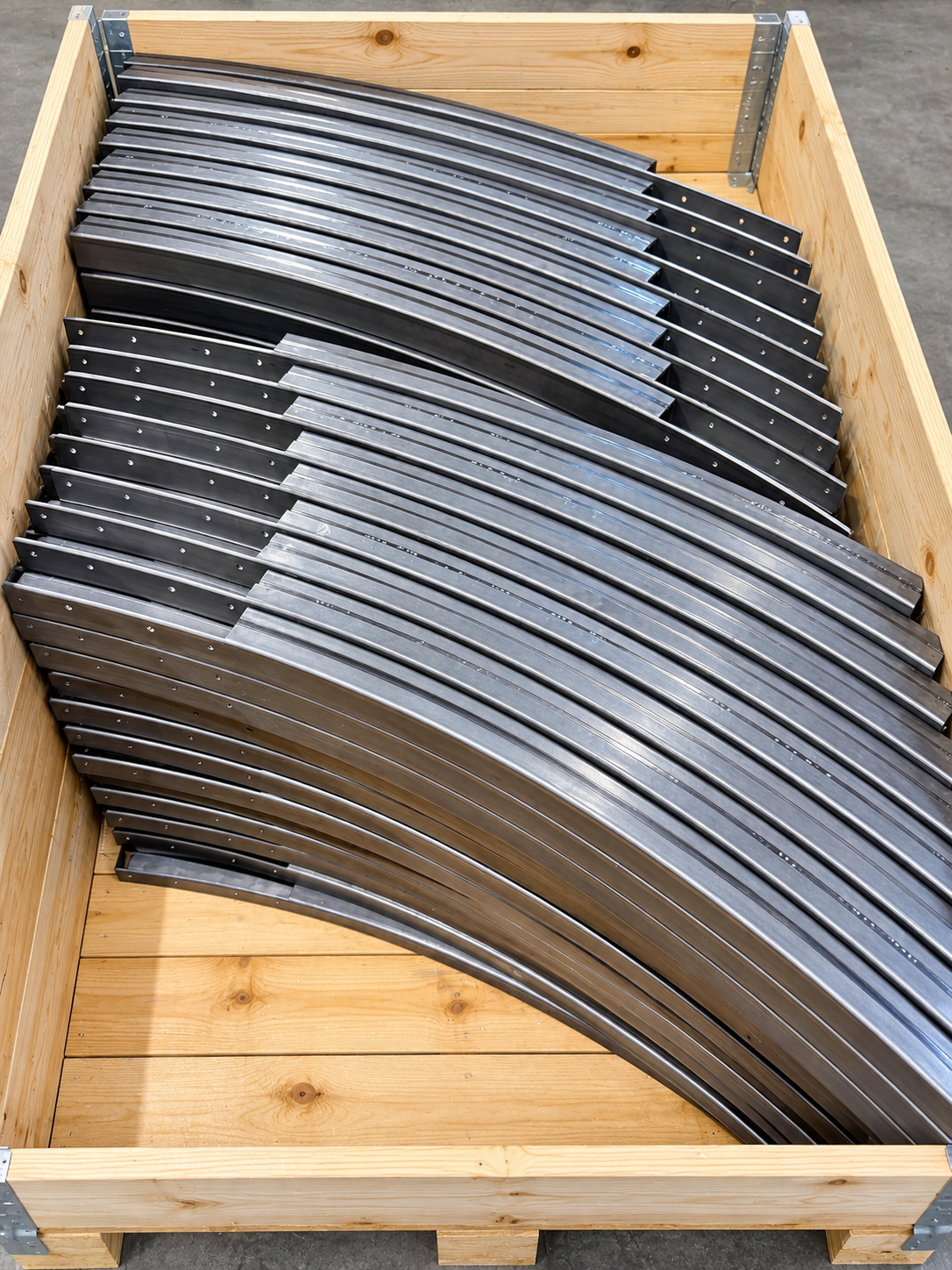 Gebogene Metallprofile in einer Holzkiste