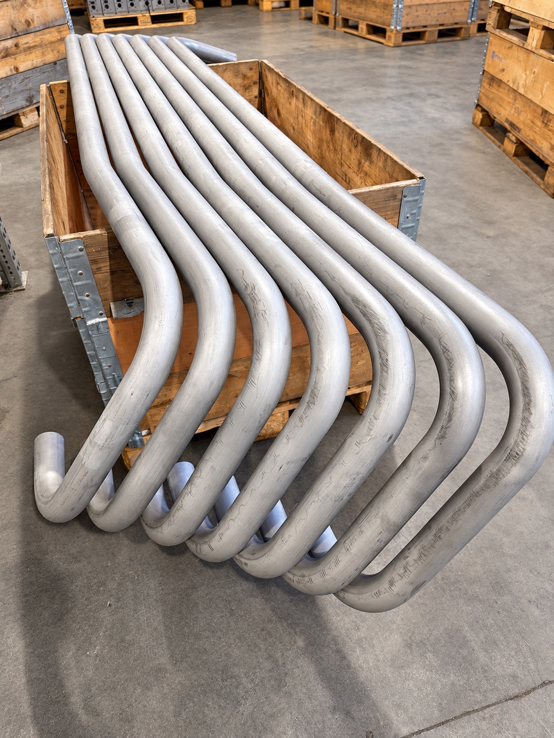 Gebogene Metallrohre in einer Transportkiste
